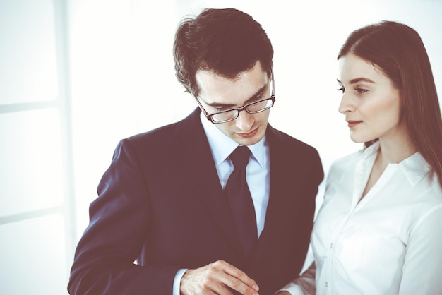 Businessmen working with computer in modern office. Headshot of male entrepreneur or company manager at workplace. Partners discussing contract. Business concept.