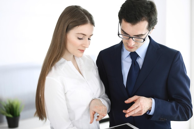 Businessmen working with computer in modern office. Headshot of male entrepreneur or company manager at workplace. Partners discussing contract. Business concept.