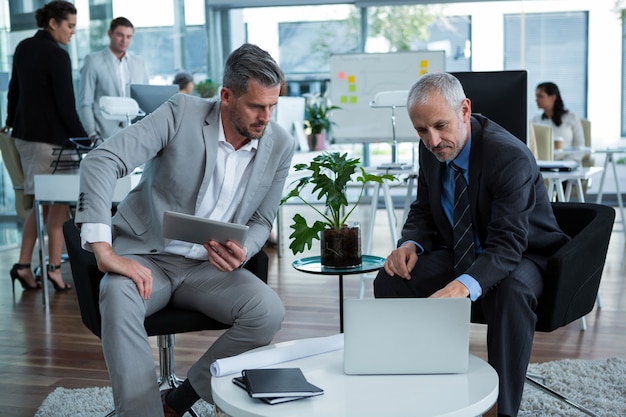 Businesspeople discussing over laptop