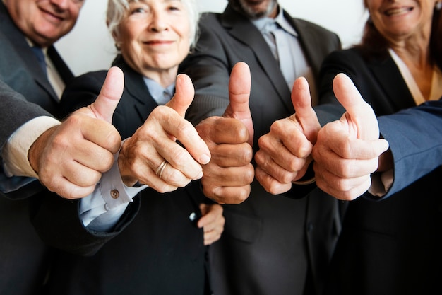 Businesspeople doing a thumbs up together