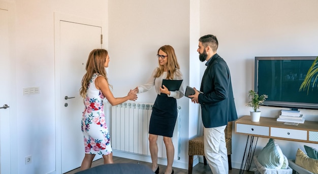 Businesspeople greeting and receiving businesswoman