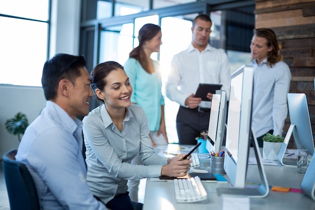 Photo businesspeople interacting while working on personal computer