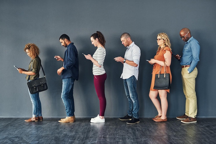 Photo businesspeople job interview and waiting in line with technology or recruitment onboarding or internet men women and meeting diversity in queue or cellphone in office human resources or hiring