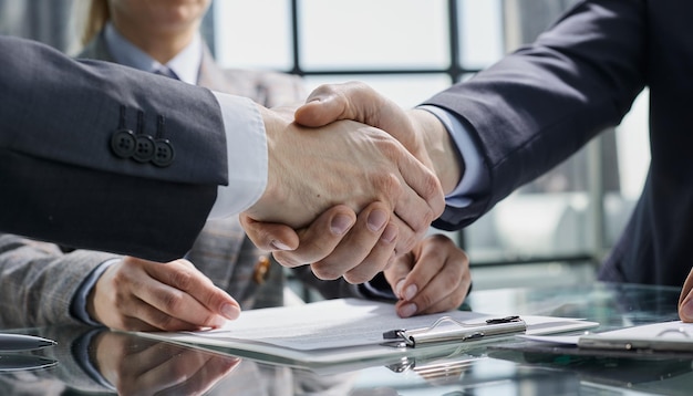 Businesspeople or lawyers shaking hands finishing up meeting or negotiation in sunny office business