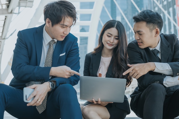 businesspeople looking at laptop and discussion about project