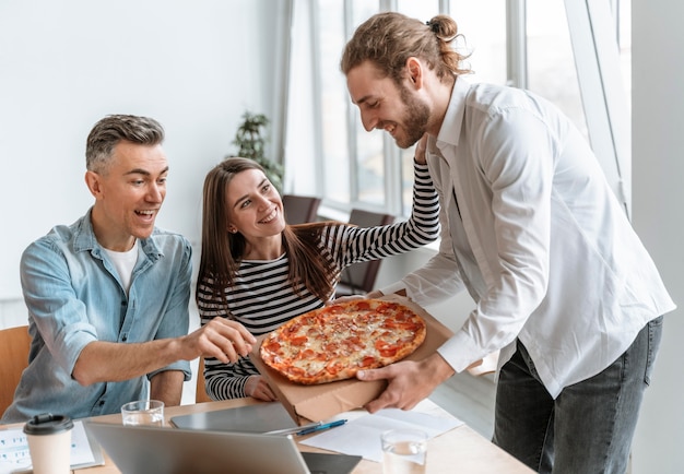 Photo businesspeople on lunch break eating pizza