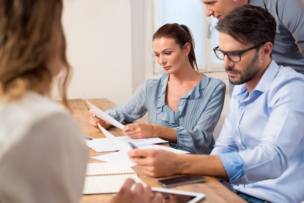 Persone di affari riunite in una sala riunioni. squadra di affari che utilizza i rapporti in una riunione. brainstorming del lavoro di squadra aziendale in ufficio.