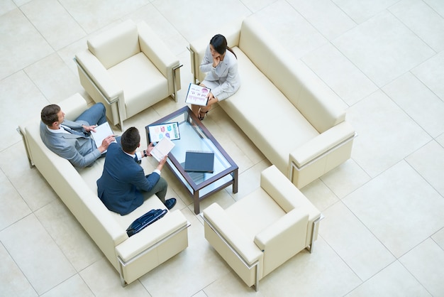 Businesspeople in a meeting on white sofas