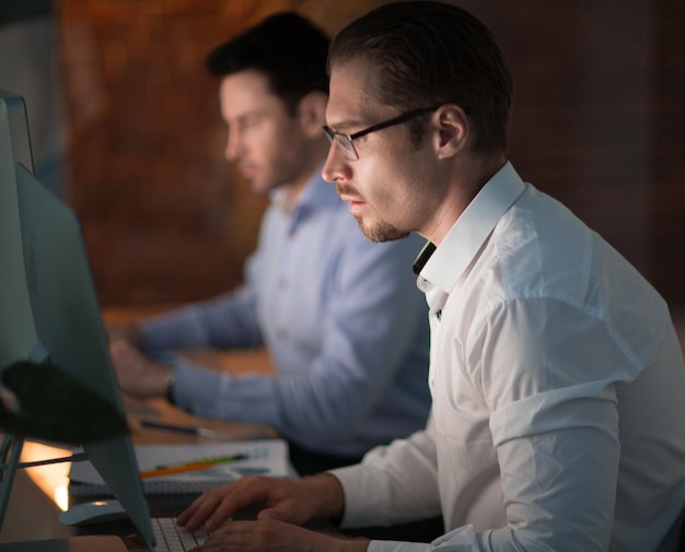 Businesspeople in the office at night working lateconcept of overtime