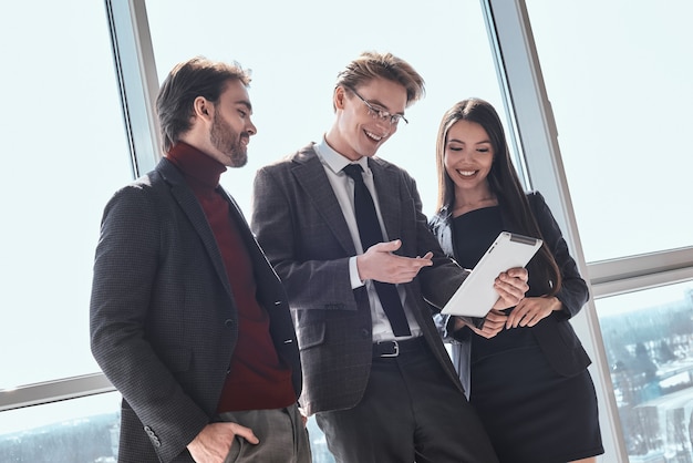 Uomini d'affari in ufficio che lavorano insieme uomo in piedi che mostra p