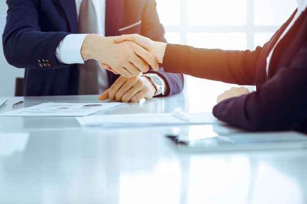 Фото Бизнесмены или юристы пожимают друг другу руки, завершая встречу или переговоры в солнечном офисе деловое рукопожатие и партнерство