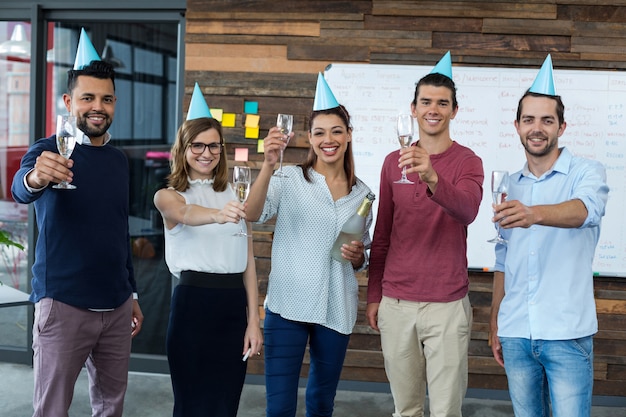 Businesspeople showing glasses of champagne in office