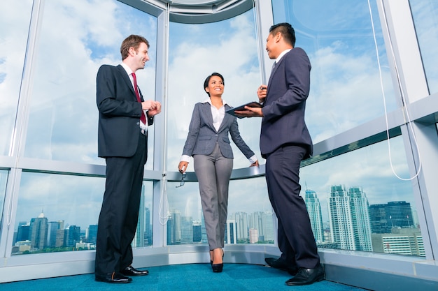 Businesspeople standing at office windo working