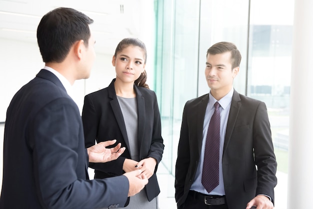 Businesspeople talking in office building hallway