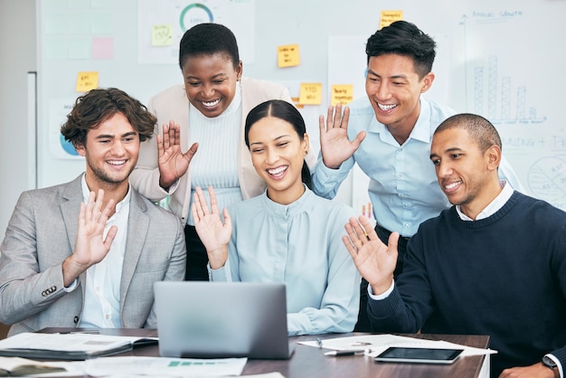 Businesspeople team or group of professionals waving and
greeting during a video conference and virtual meeting on a laptop
diverse employees of b2b advertising and marketing agency saying
hello