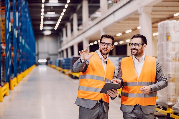 Businesspeople tour the warehouse with tablet in hands