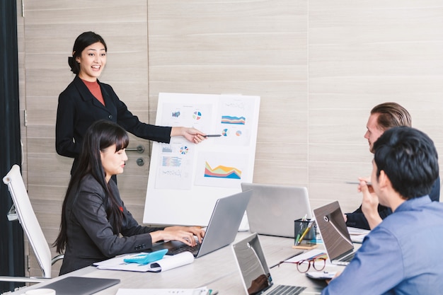 Businesspeople using laptops and discussing together in meeting room.Teamwork concept