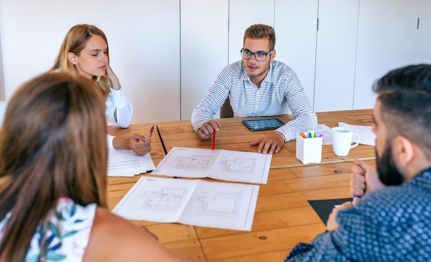 Businesspeople in a work meeting looking at construction drawings