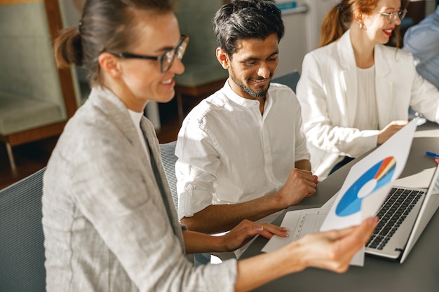 Businesspeople working together in bright office sitting at desk