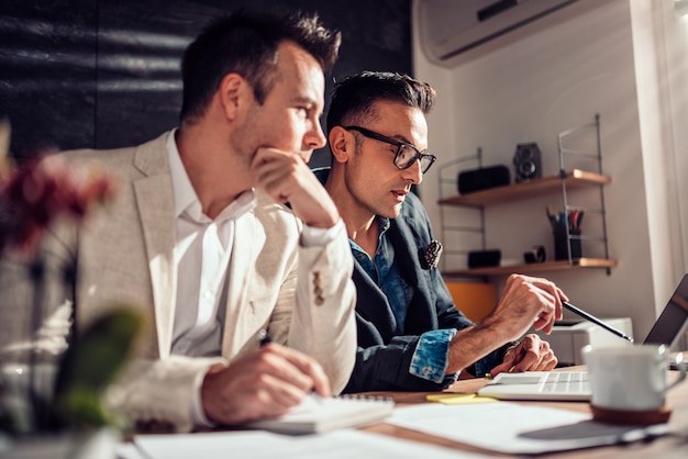 Businesspeople working together in office and using laptop