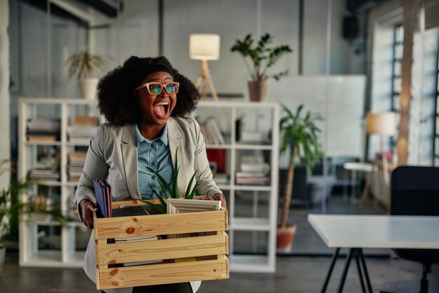 Businessperson carrying office supplies in plastic container