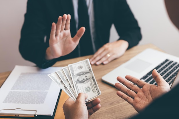 Photo businessperson refusing bribe given money by partner with anti bribery corruption concept