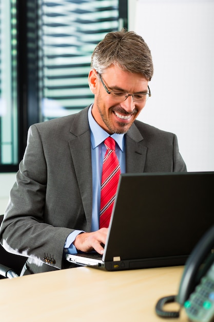 Businessperson with laptop in his business office