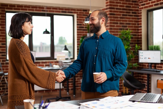 Businessteam shaking hands during company meeting in startup office working at business investment preparing marketing presentation. Businesspeople analyzing management papaerwork with strategy