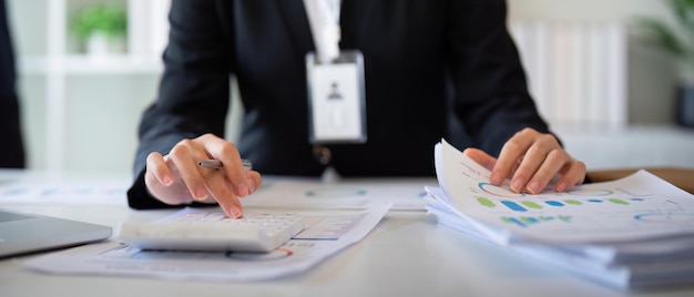 Бизнес-бухгалтер, использующая калькулятор и ноутбук для сохранения финансовых данных в офисном помещении Бизнес-концепция финансового налогового учета.