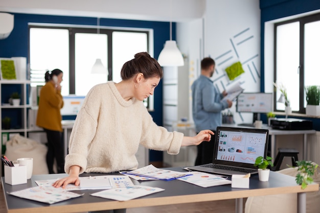 Businesswoman analysing financial statistics standing in start up office