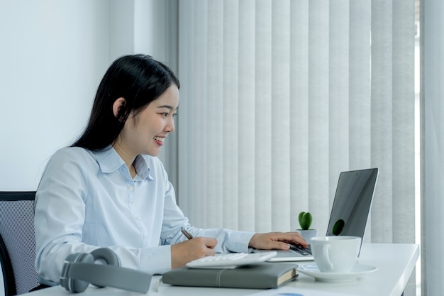 Imprenditrice analisi del grafico e riunione videoconferenza con il laptop in ufficio a casa per la definizione di obiettivi aziendali sfidanti e la pianificazione per raggiungere il nuovo obiettivo.