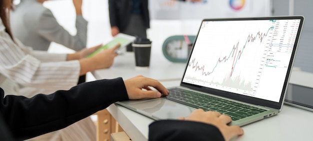 Businesswoman in analyze stock market data using laptop computer proficiently