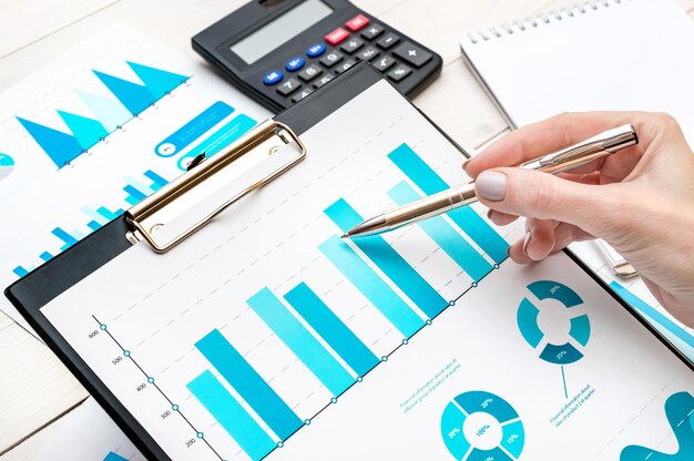 Businesswoman analyzing business document on clipboard at workplace Business concept