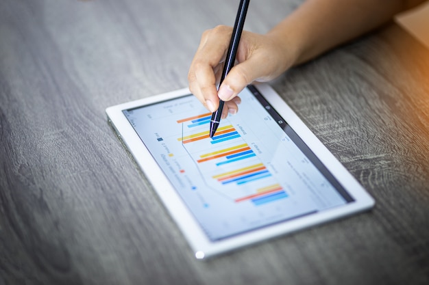 businesswoman analyzing graphs on a digital tablet in an office