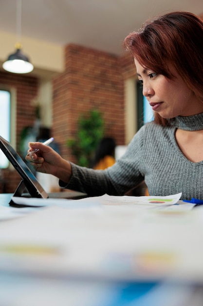 Donna di affari che analizza i grafici di gestione sul computer tablet che lavora al progetto aziendale nell'ufficio di avvio. executive manager brainstorming di idee di marketing per la pianificazione di una nuova strategia, concetto di business