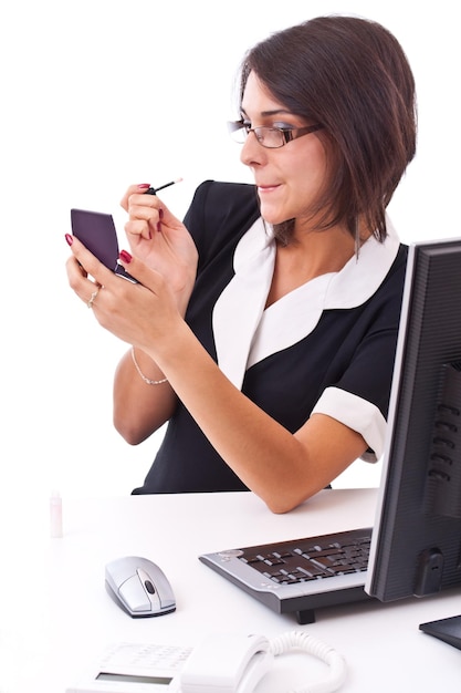 Businesswoman applying lipstick