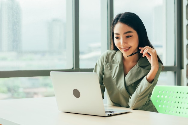 Businesswoman are smile and using computer at window office Trade stock market