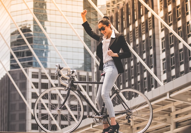 Businesswoman. Beautiful woman enjoying city ride by bicycle