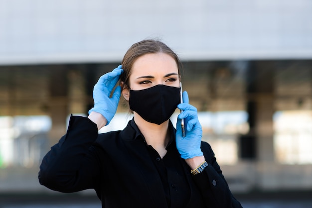 Businesswoman in a black suit and a black medical mask