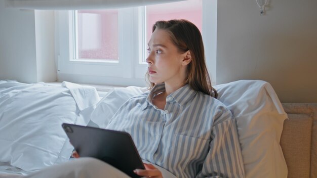 Businesswoman browsing tablet bedroom at morning routine closeup Serious woman