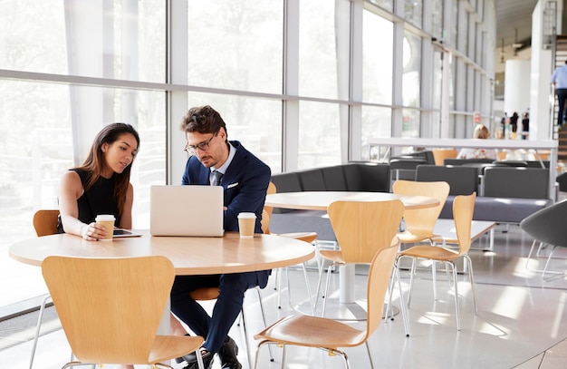 Businesswoman and businessman looking at laptop