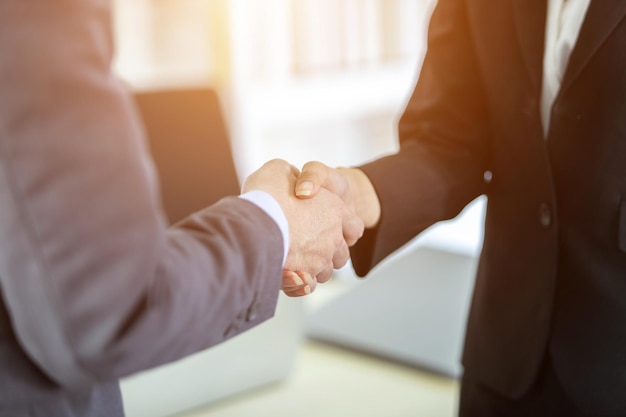 Businesswoman and businessman shaking hands at In the office room background after the contract is signed or handshake greeting dealbusiness expressed confidence embolden and successful concept