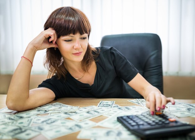 Businesswoman calculating income on a calculator