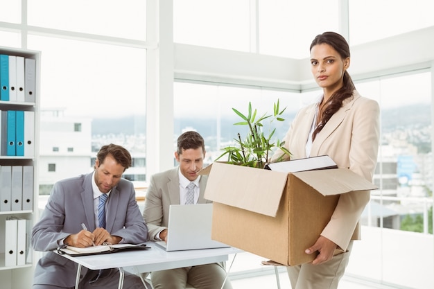 Businesswoman carrying her belongings in box