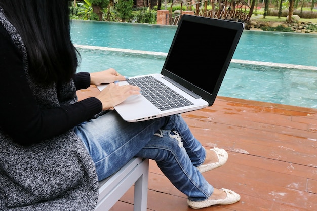 Businesswoman, Charming beautiful tan skin Asian business chic woman hand work on laptop at swimming pool