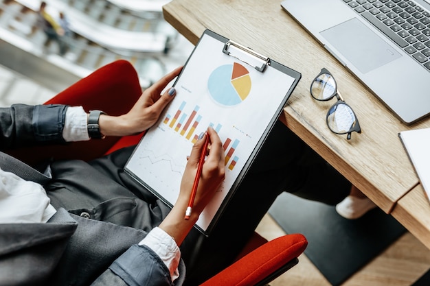 Photo businesswoman checks charts at work