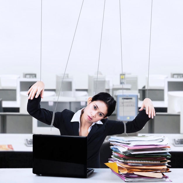 Photo businesswoman controlled by strings