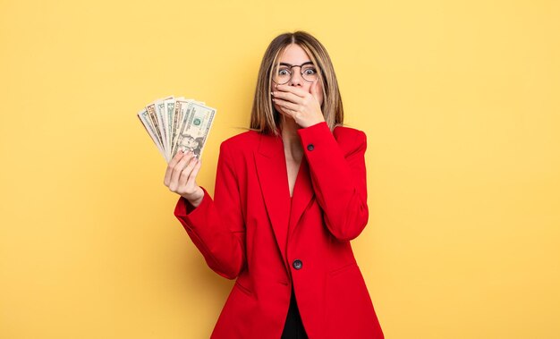 Businesswoman covering mouth with hands with a shocked. dollar banknotes concept