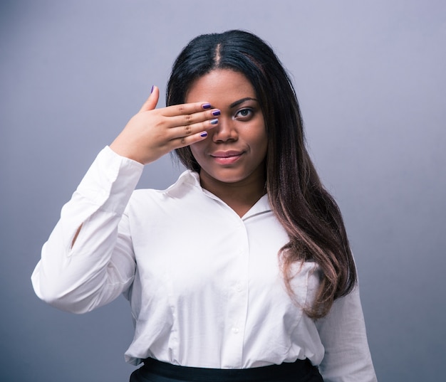 Businesswoman covering one eye with hand