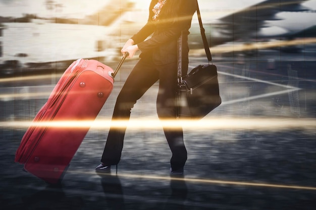 Businesswoman dragging heavy luggage in airport